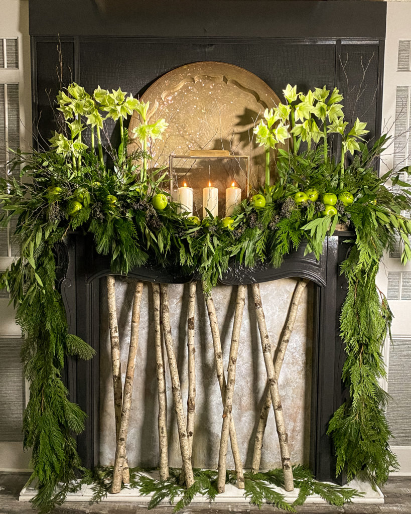 Green flowers and green apples on mantle with garlands to match