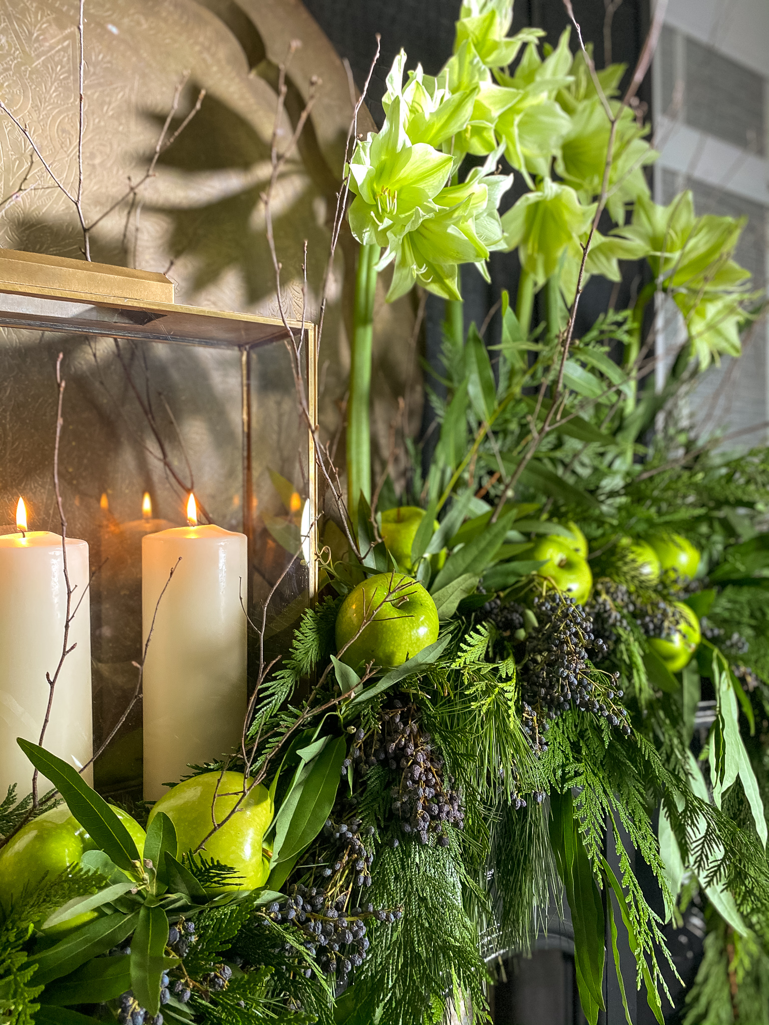 Green flowers and green apples on mantle with garlands to match