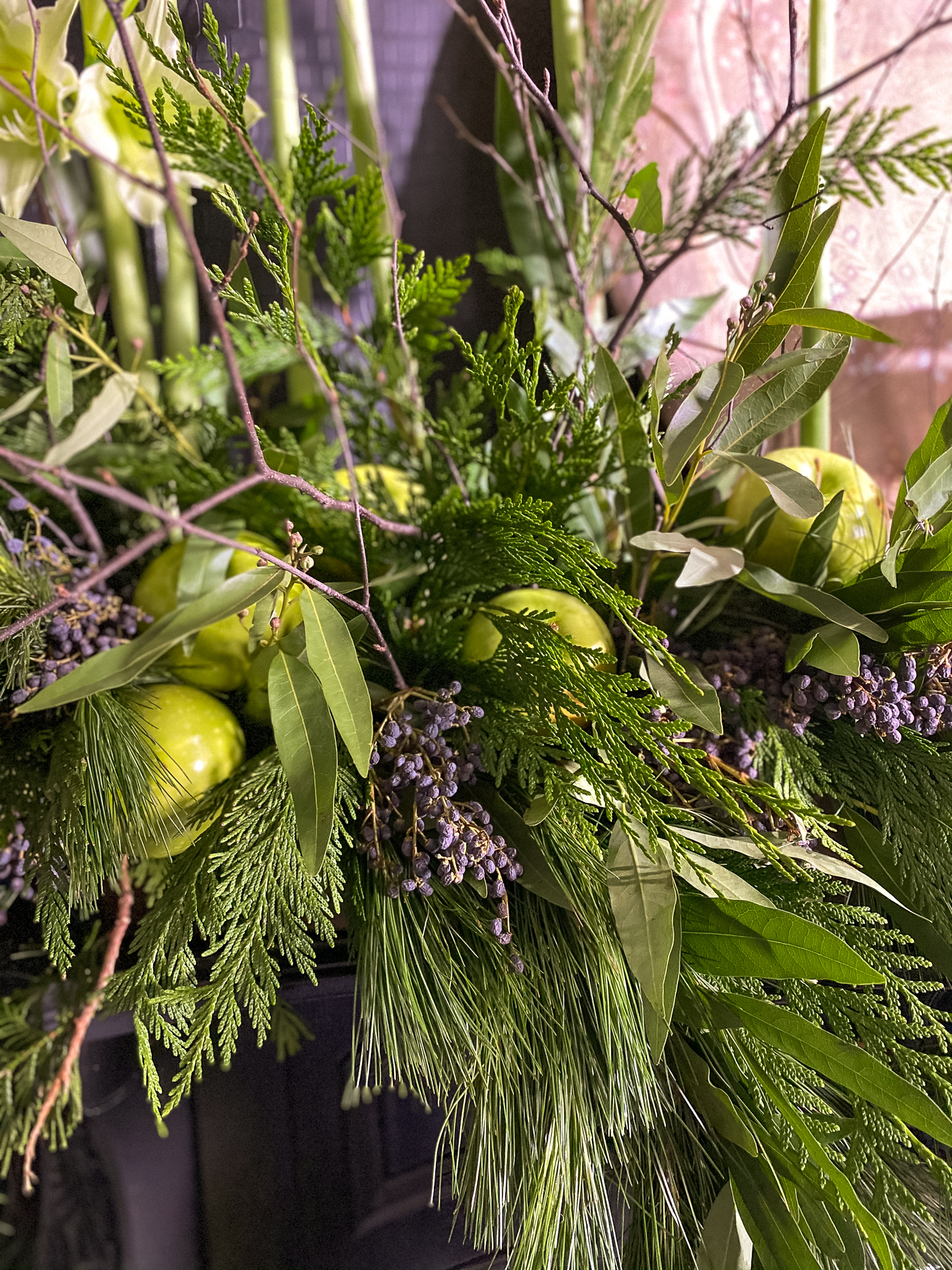 Green flowers and green apples on mantle with garlands to match