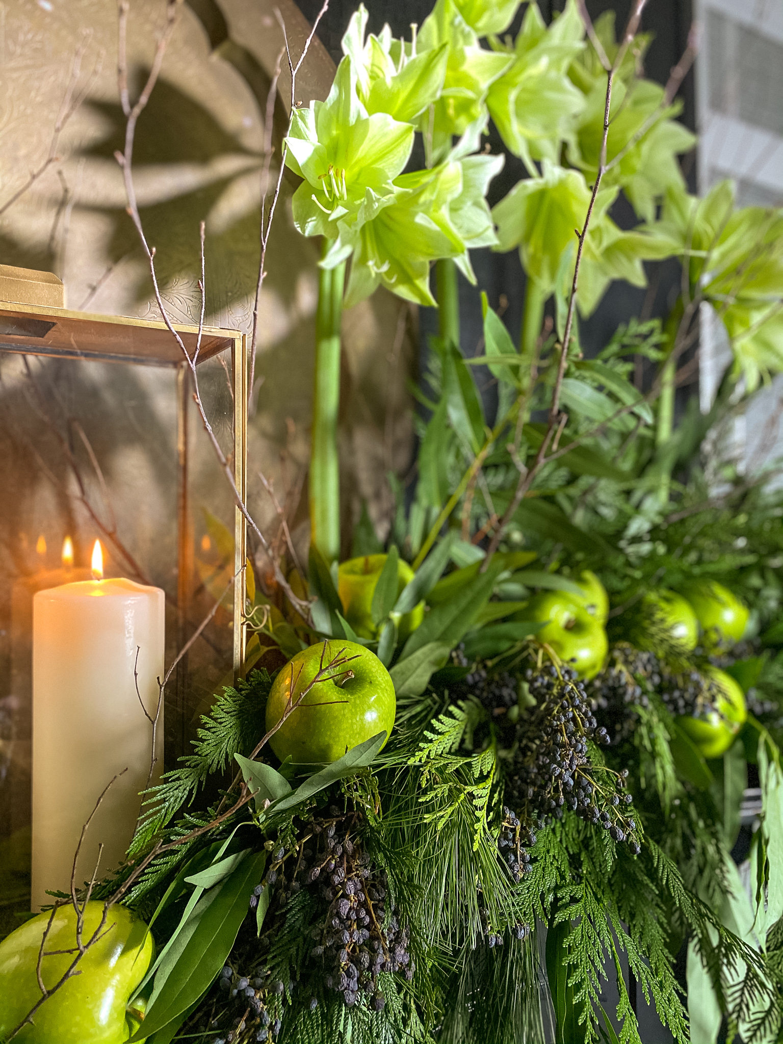 Green flowers and green apples on mantle with garlands to match