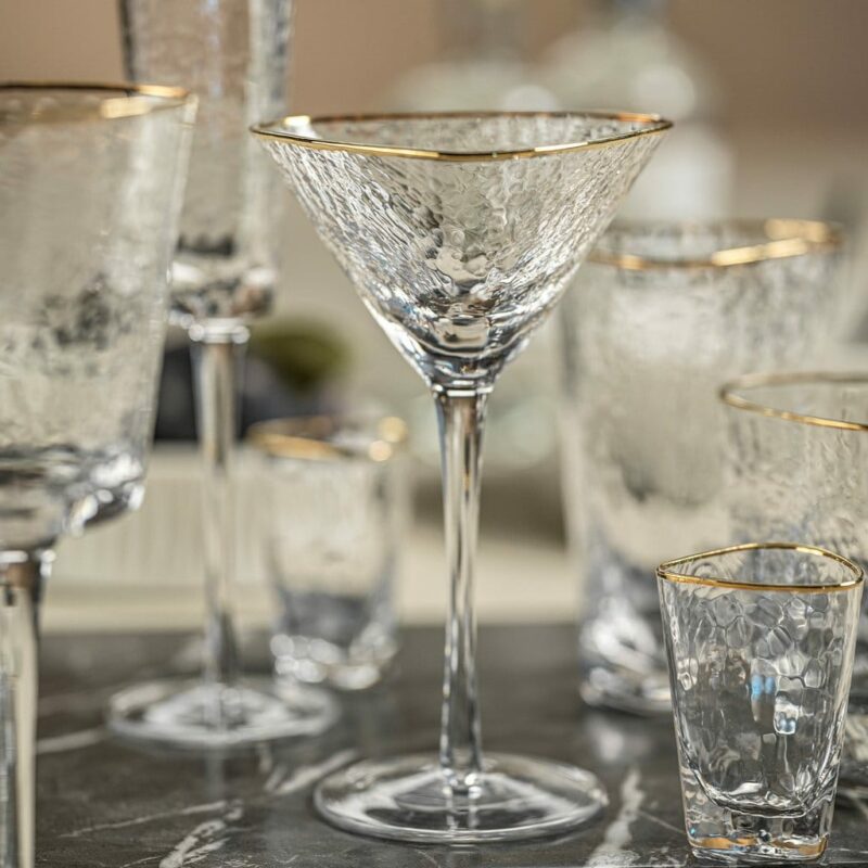 gold rimmed triangular shaped stemmed martini glass displayed with other glasses from the same collection