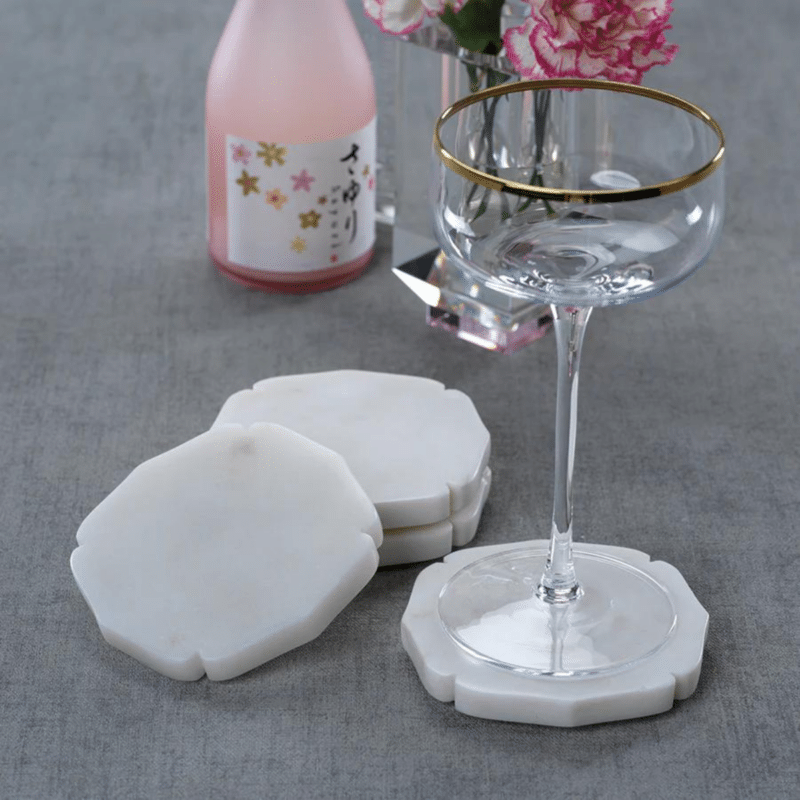 white marble coasters in a set of 4 with a carved moorish design